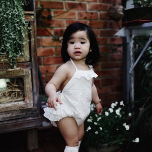 Side view of Ivory ruffle toddler girls romper