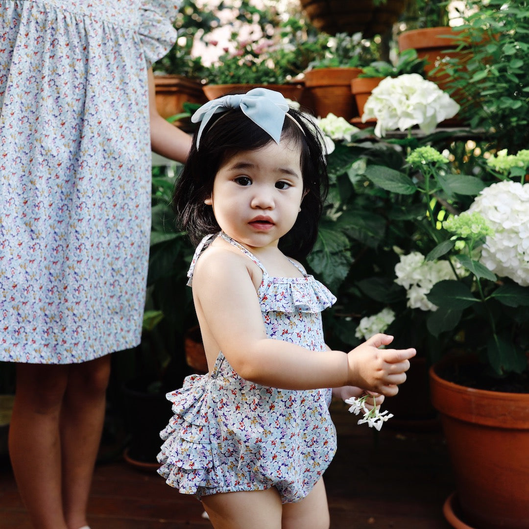 Sideview of the the duck egg blue floral toddler romper